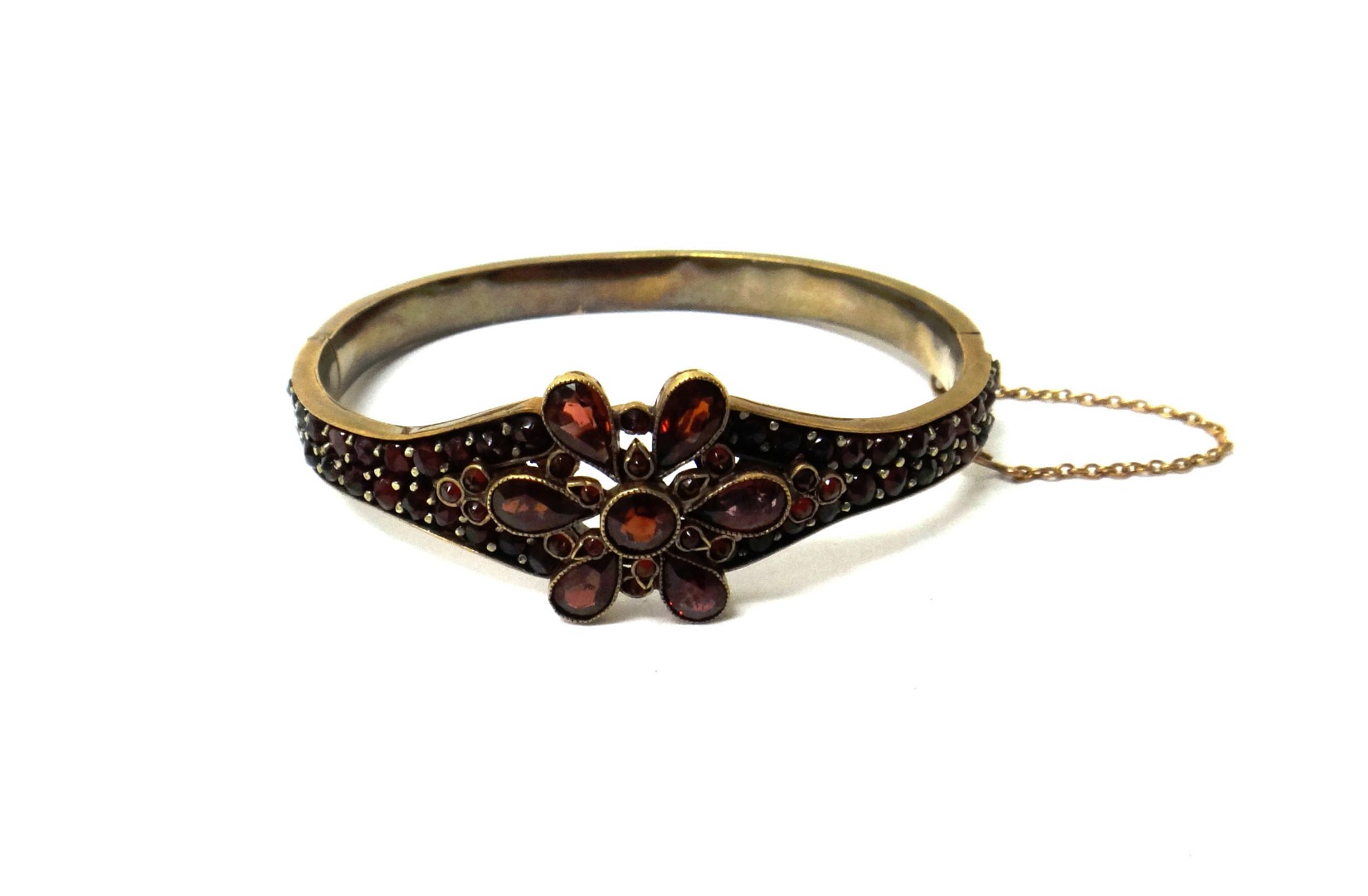 Appraisal: A Bohemian garnet set oval hinged bangle the front with