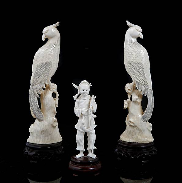 Appraisal: A Pair of carved ivory birds on tree trunks height