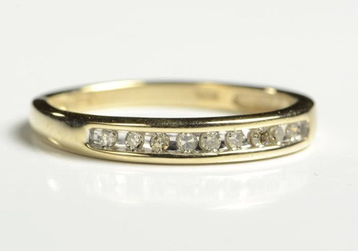 Appraisal: DIAMOND AND TEN KARAT GOLD RING with nine channel set