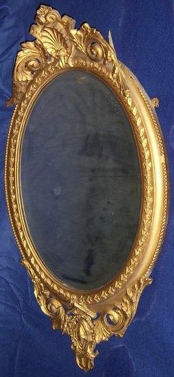 Appraisal: An oval mirror with gilt plaster frame and shell surmount