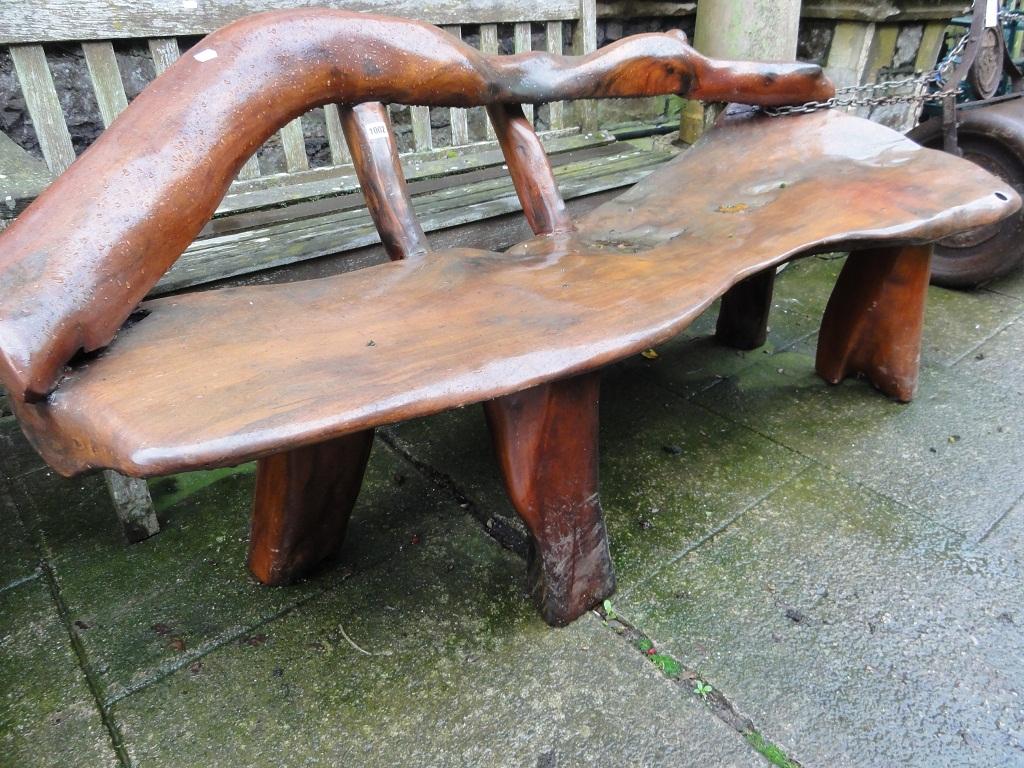 Appraisal: A rustic hardwood garden bench with rough hewn plank seat