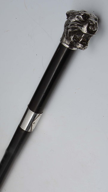 Appraisal: AN EBONISED WALKING CANE the silver tigers head knob inset