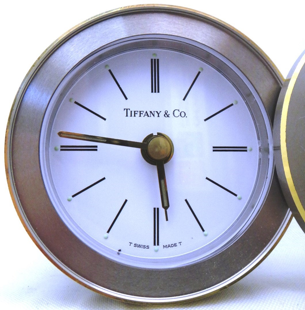 Appraisal: A Tiffany Co circular steel cased alarm clock with a