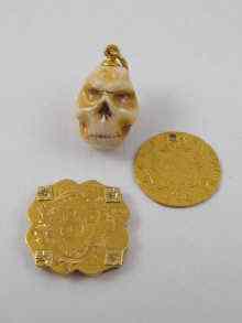 Appraisal: A ceramic finely detailed miniature skull pendant with gold loop