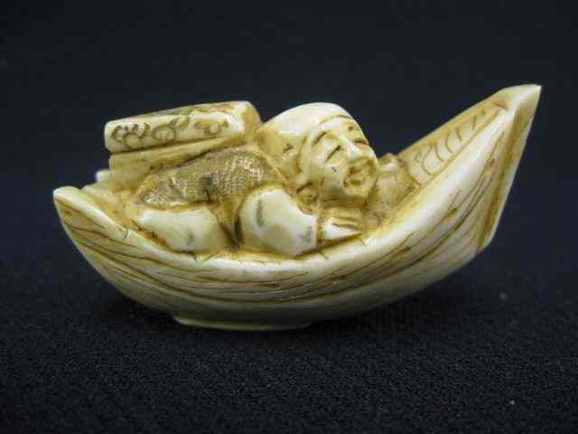 Appraisal: Carved Ivory Netsuke of a Man in boat back pack