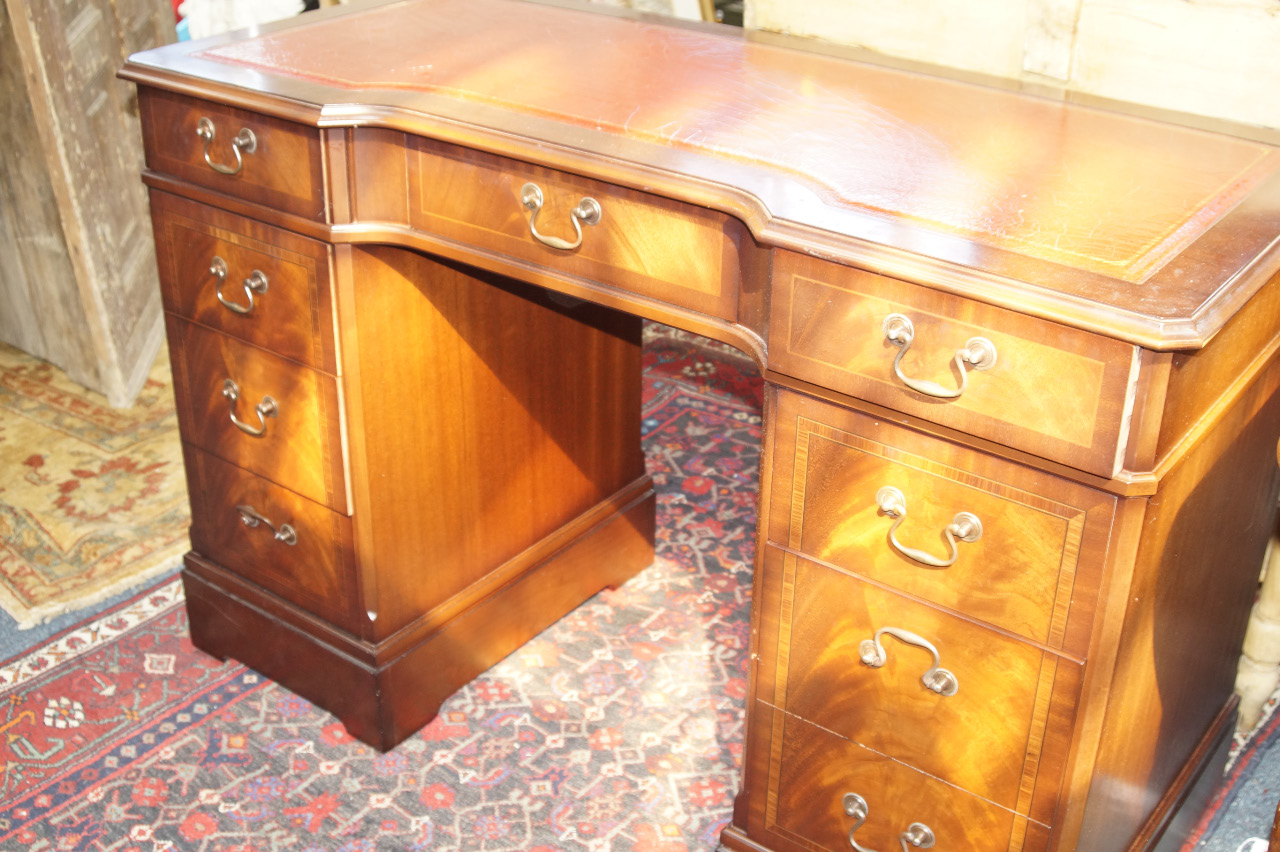 Appraisal: A Georgian style reproduction mahogany kneehole desk with slightly recessed