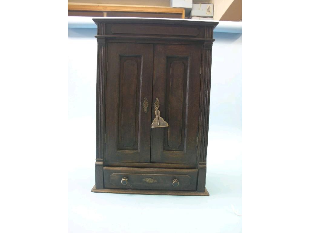 Appraisal: A late th century dark oak wall cupboard enclosed by