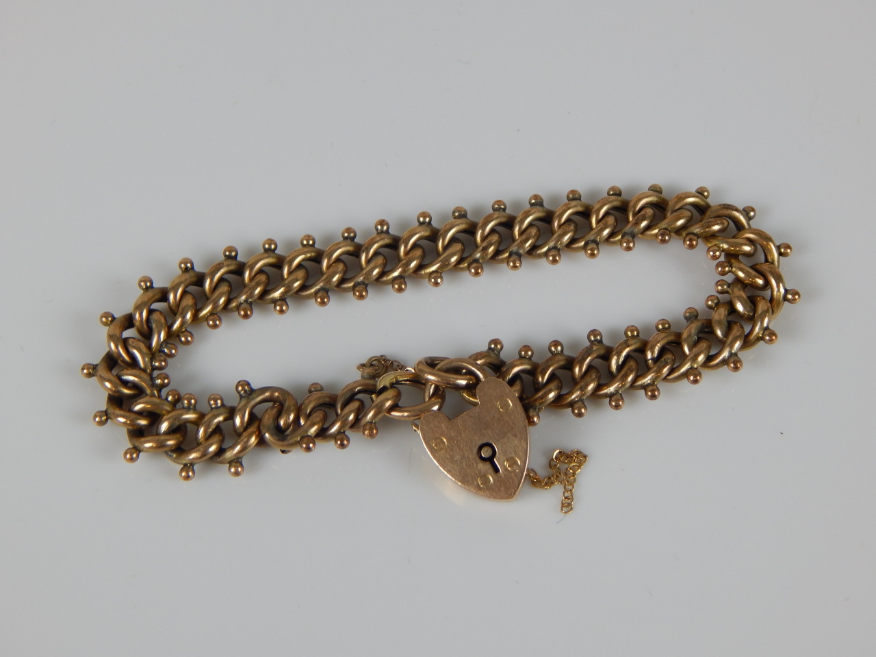 Appraisal: A ct gold charm bracelet with abstract fancy links padlock