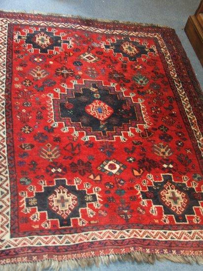 Appraisal: AN EASTERN RED GROUND RUG with a central medallion in