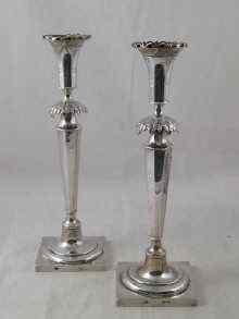 Appraisal: A pair of silver candlesticks the square bases rising through