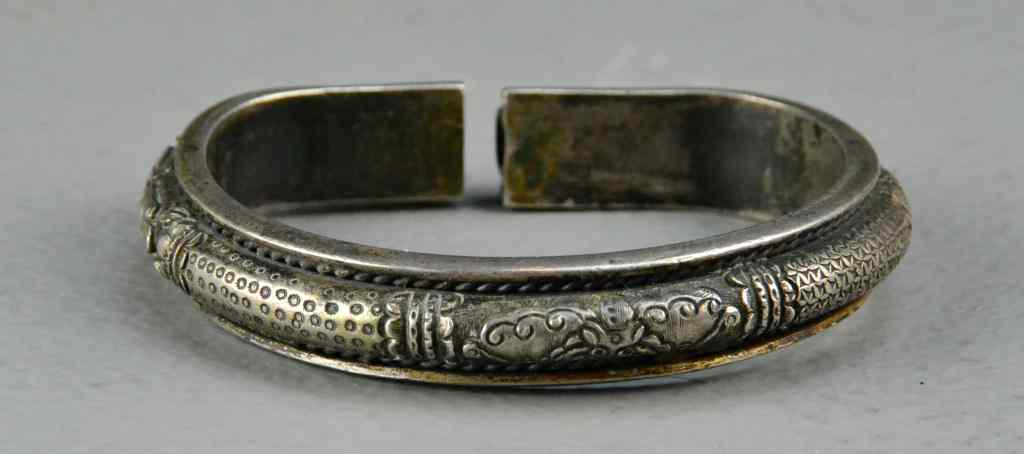 Appraisal: Chinese Qing Silver BangleMolded to depict lotus blossoms and other