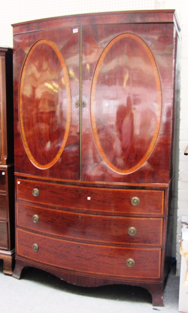 Appraisal: A Regency style satinwood banded mahogany bowfront linen press the