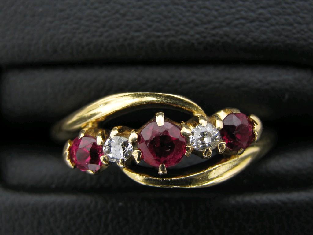 Appraisal: A Ruby and Diamond five stone cross-over Ring claw-set three