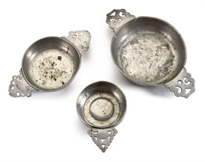 Appraisal: Group of three pewter porringers th century The keyhole handles