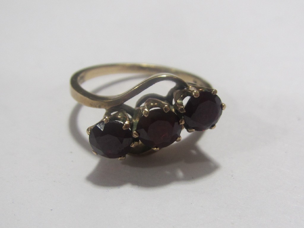 Appraisal: Nine carat gold garnet three stone twist ring