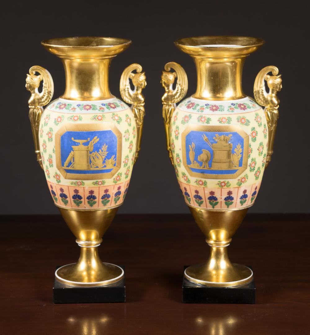 Appraisal: PAIR OF PORCELAIN URNS with figural arms and painted motif