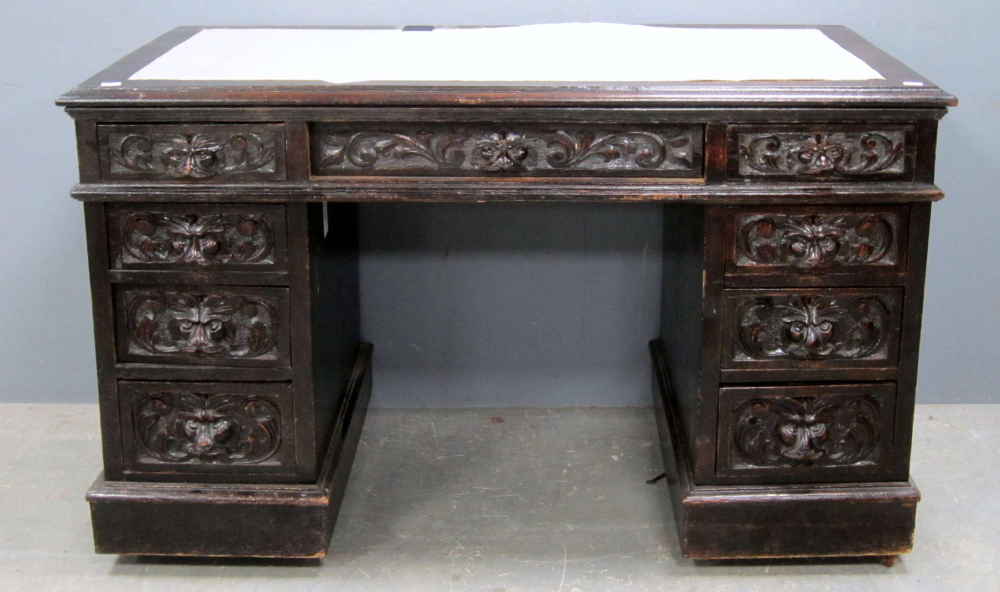 Appraisal: A carved oak pedestal desk the central drawer flanked by