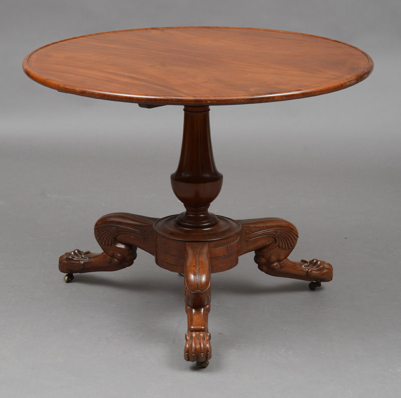 Appraisal: EMPIRE CARVED MAHOGANY TILT-TOP CENTER TABLE The circular molded top