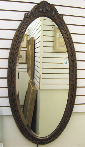 Appraisal: AN OVAL WALL MIRROR having carved hardwood frame inset with