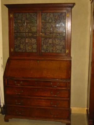 Appraisal: AN OAK BUREAU CABINET associated with moulded and dentil cornice