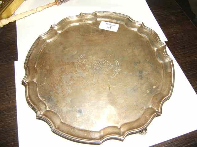 Appraisal: A SILVER SALVER with pie crust edge standing on scrolling