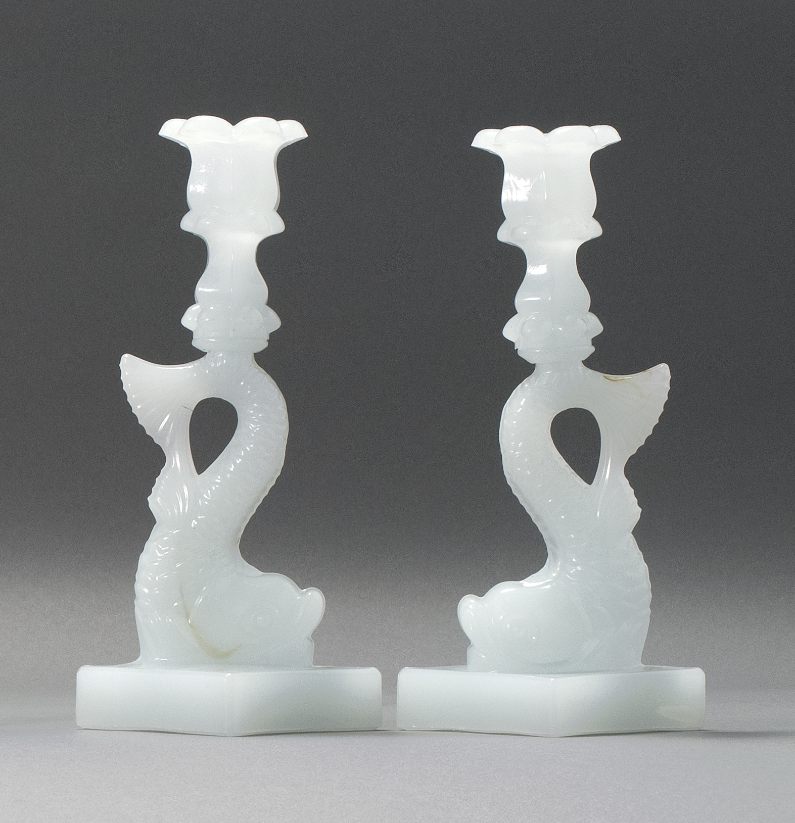 Appraisal: PAIR OF SANDWICH GLASS COMPANY PRESSED GLASS DOLPHIN CANDLESTICKS Mid-