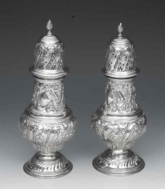 Appraisal: A PAIR OF EDWARDIAN SILVER CASTERS with pressed scroll and