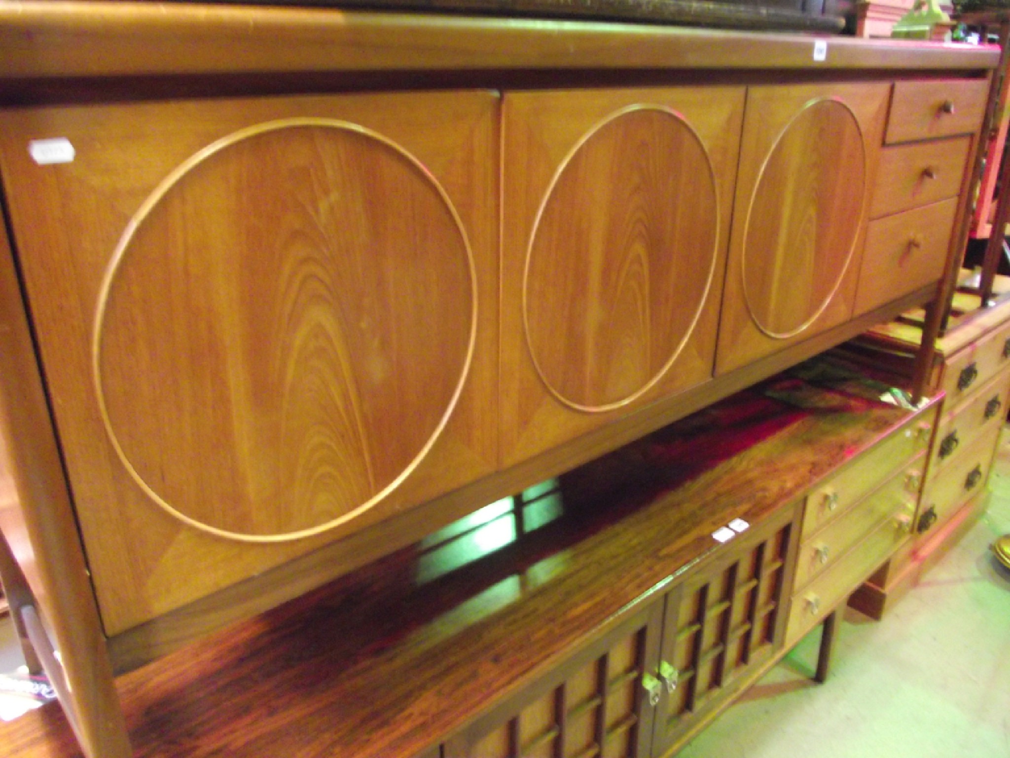 Appraisal: A mid th century long and low teak sideboard partially