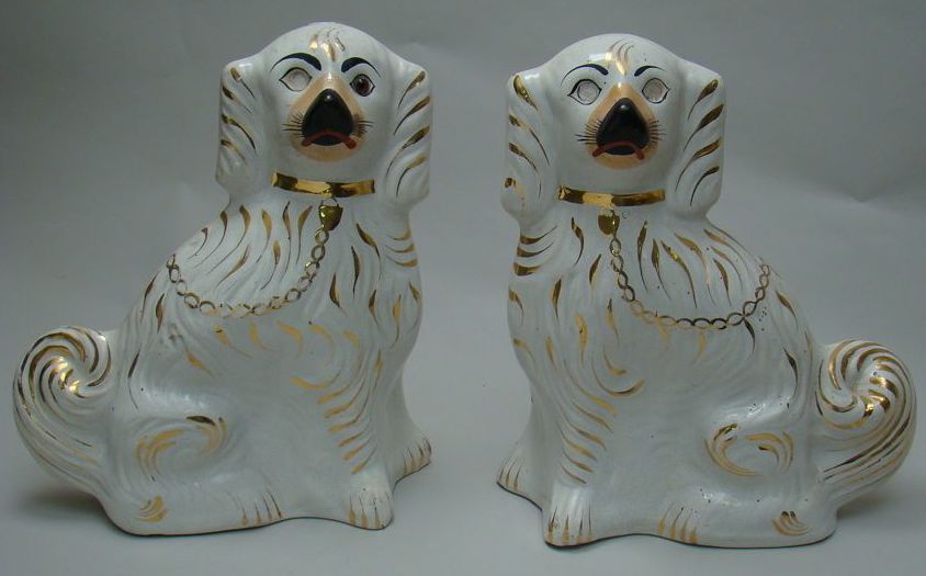 Appraisal: PAIR OF WHITE STAFFORDSHIRE SPANIELS With gilt highlights One missing