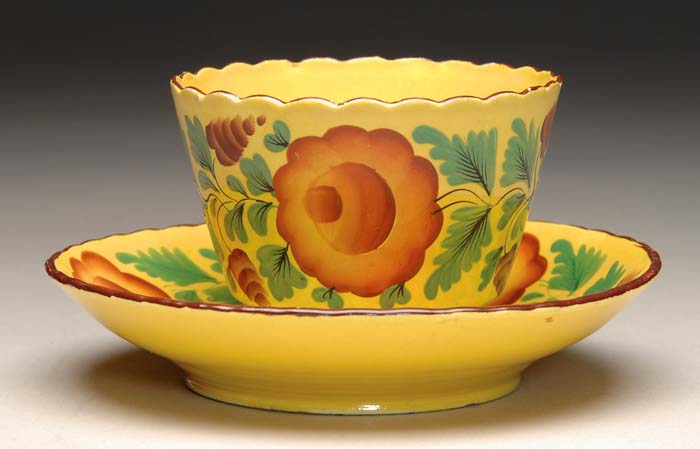 Appraisal: CANARY YELLOW FLOWER DECORATED CUP AND SAUCER Scalloped rim handless