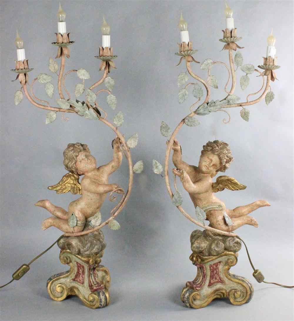 Appraisal: A PAIR OF PAINTED AND GILTWOOD CHERUBS probably th century