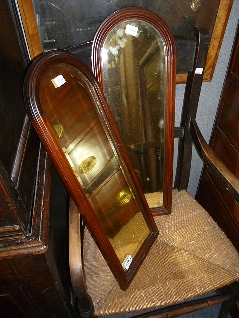 Appraisal: A PAIR OF ARCHED TOP OAK FRAMED MIRRORS with bevelled