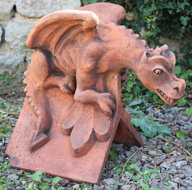 Appraisal: A TERRACOTTA RIDGE TILE surmounted by a crouching winged dragon