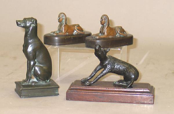 Appraisal: A group of four small patinated bronze dogs or sphinxes