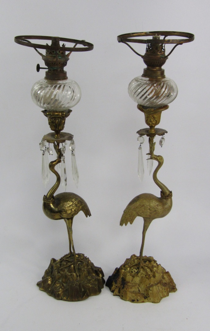 Appraisal: A pair of cast metal oil lamps cast as crowned