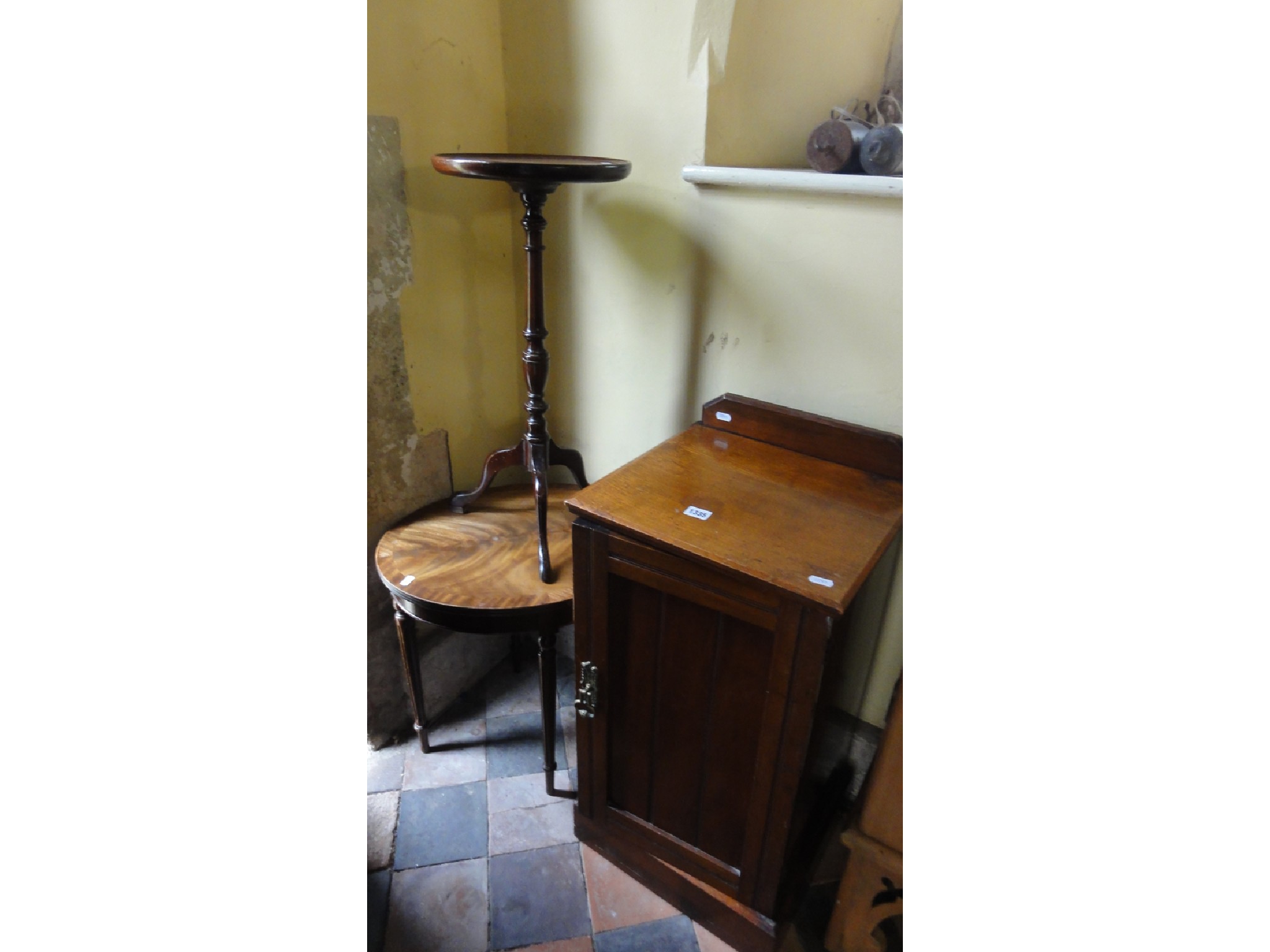 Appraisal: An Edwardian raised oak bedside cupboard enclosed by a panelled