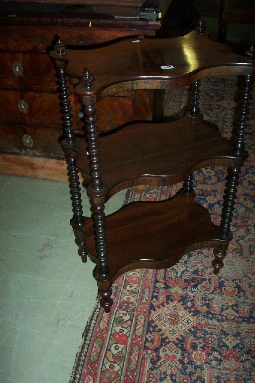 Appraisal: A Victorian rosewood -tier whatnot with shaped outline and bobbin