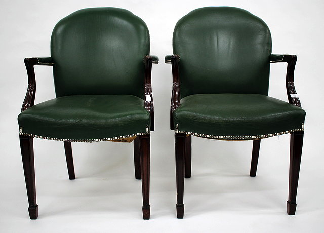 Appraisal: A PAIR OF GREEN LEATHER UPHOLSTERED LIBRARY ARMCHAIRS with shaped