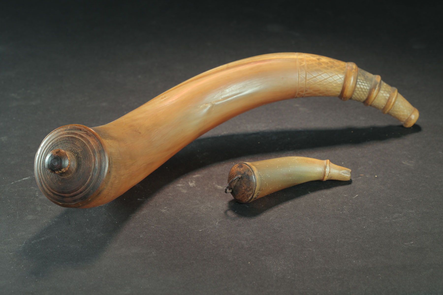 Appraisal: THREE POWDER HORNS FLASKS Nineteenth century Large horn with a