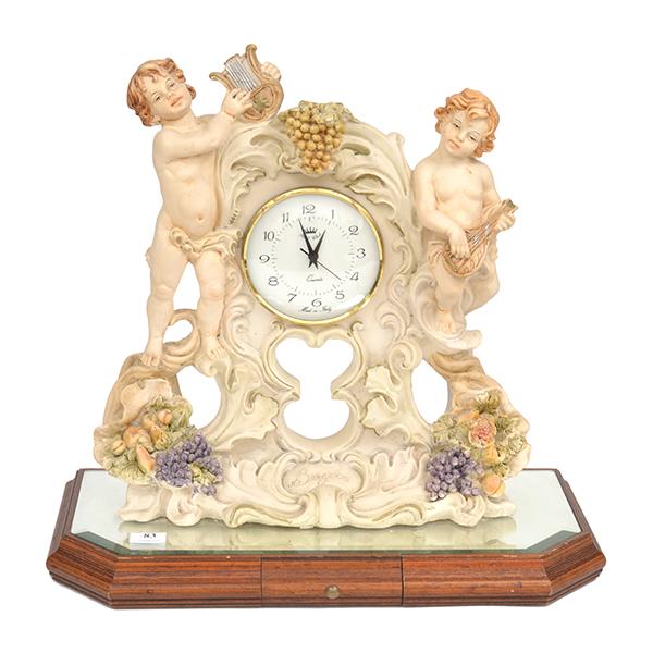 Appraisal: A COMPOSITE FRAMED FIGURAL MANTEL CLOCK WITH A MIRRORED BASE