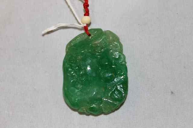 Appraisal: A CHINESE CARVED SPINACH JADE PENDANT