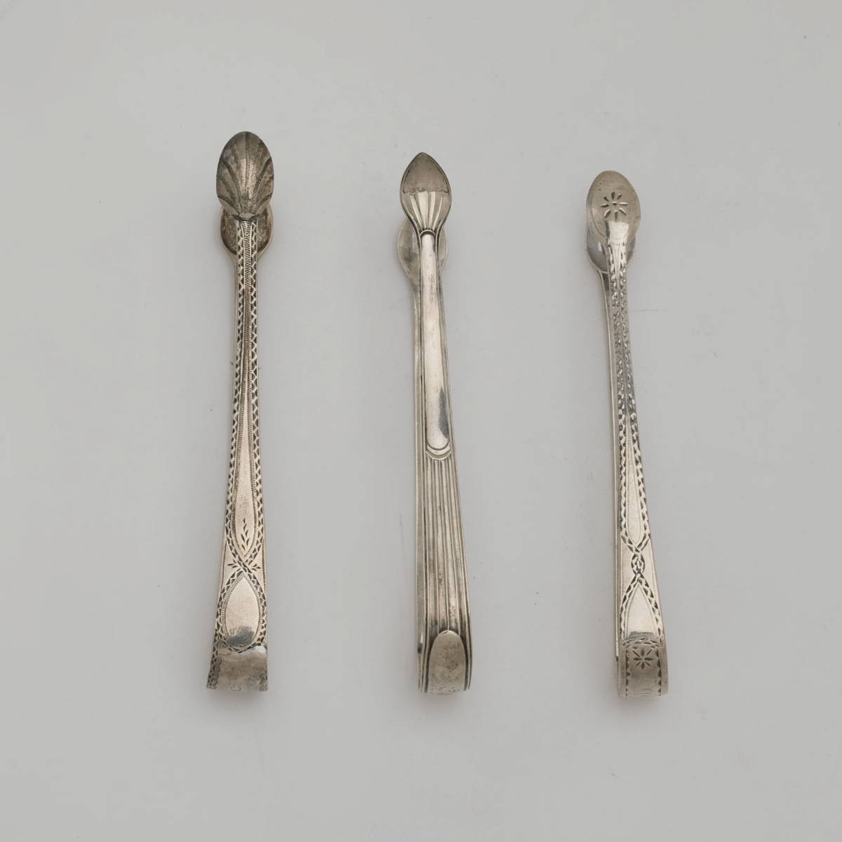 Appraisal: TWO GEORGE III SILVER PAIRS OF SUGAR TONGS LONDON PETER