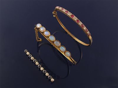 Appraisal: A gold hinged bangle alternately set with rubies and diamonds