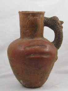 Appraisal: A large hand moulded coarse earthenware ewer the handle with