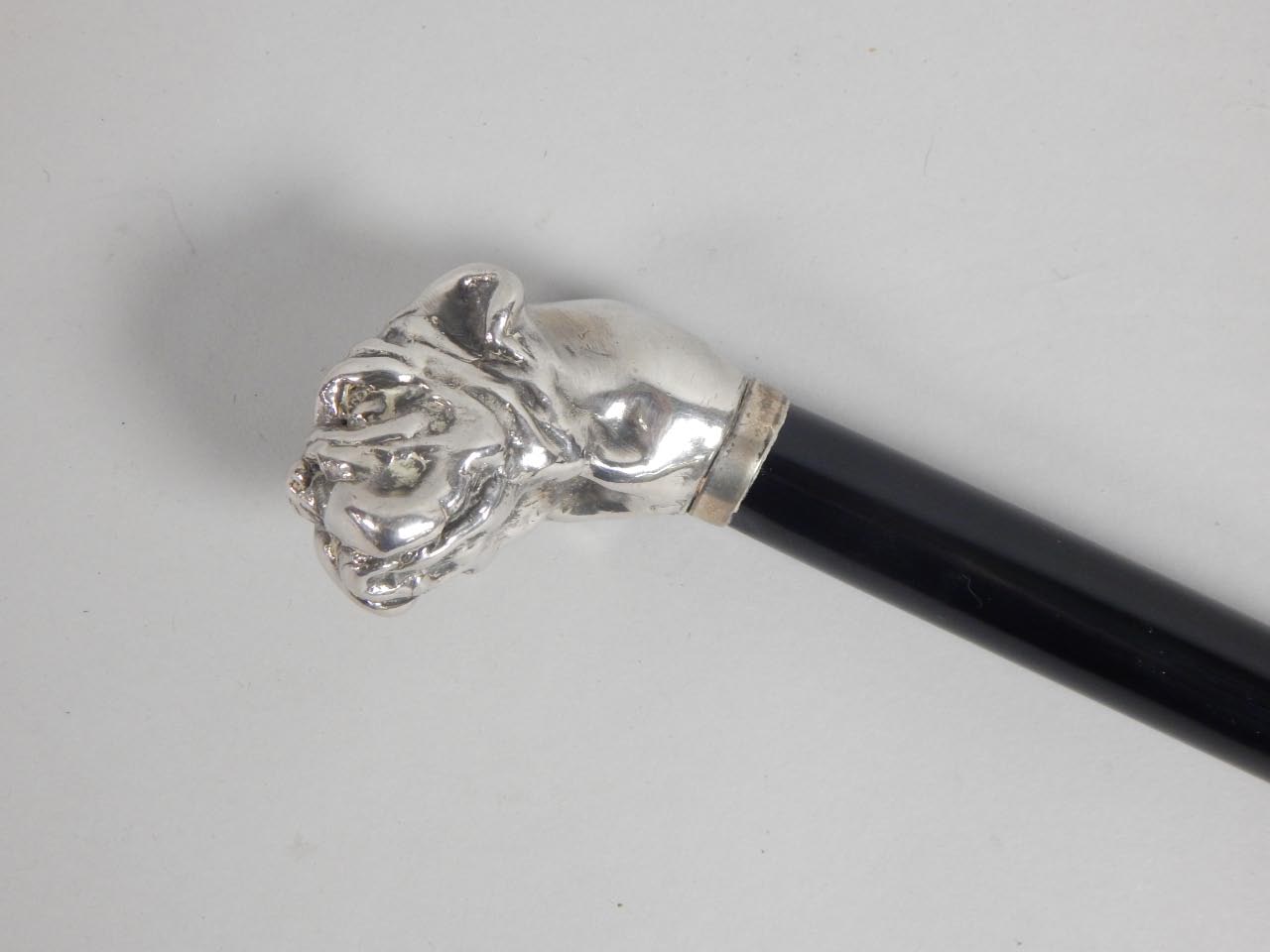 Appraisal: A late thC ebonised walking stick the silver handle modelled