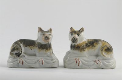 Appraisal: A pair of Staffordshire models of cats lying down with