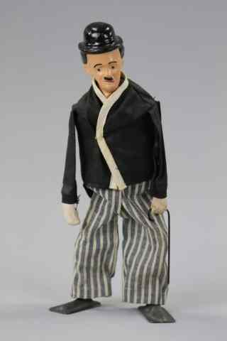 Appraisal: CHARLIE CHAPLIN WALKING FIGURE Composition head cloth outfit lead shoes