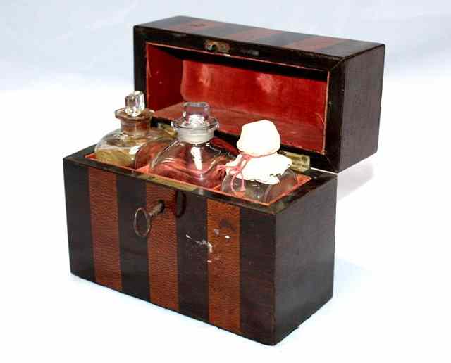 Appraisal: A MAHOGANY VENEERED APOTHECARY SET with vertical sections and three