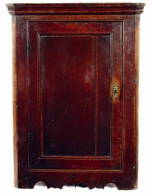 Appraisal: A George III oak hanging corner cupboard with a panelled