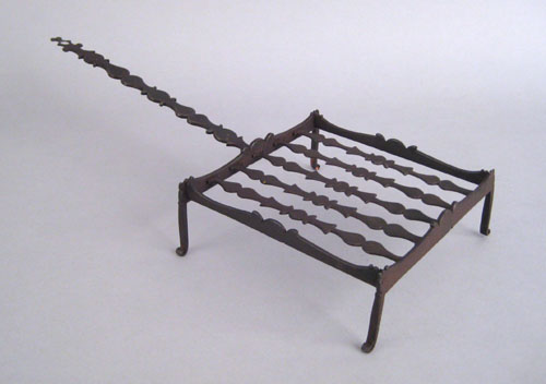 Appraisal: Elaborate wrought iron broiler ca with a scalloped handle and